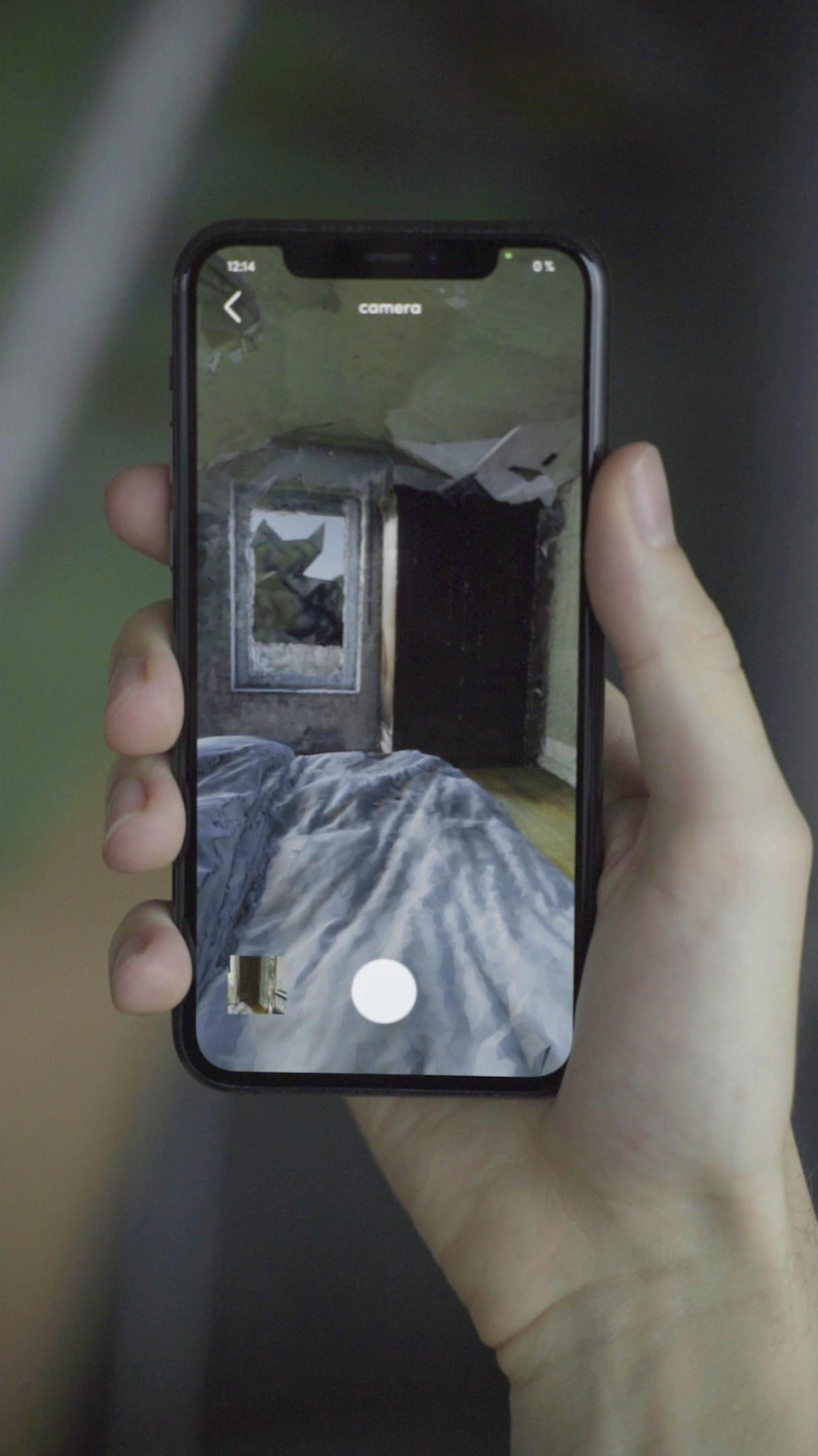 smartphone in a hand showing a camera app with a 3d scanned enwironment